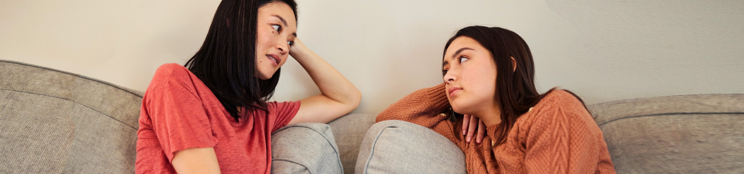 Padre y adolescente hablando sobre salud mental en el sofá.