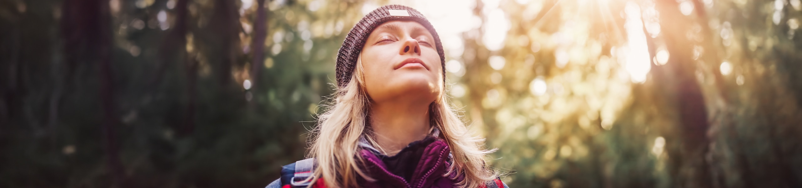 Una persona respirando profundo mientras practica meditación al aire libre