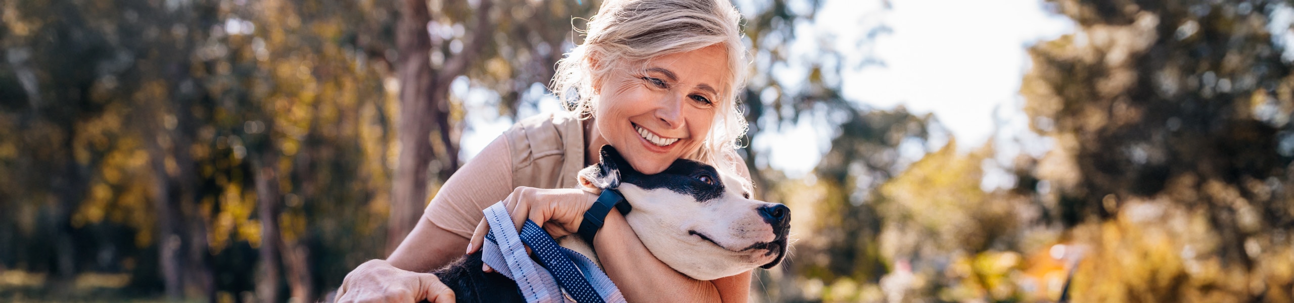 Persona sonriendo mientras abraza a un perro