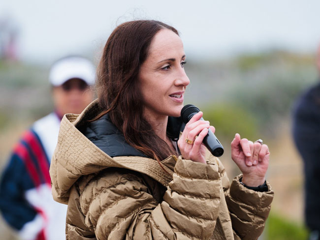 Olympian Shannon Rowbury speaking into a microphone in front of a crowd