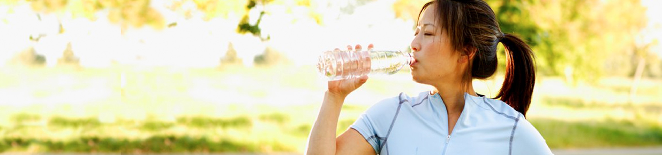 Persona bebiendo agua de una botella al aire libre 