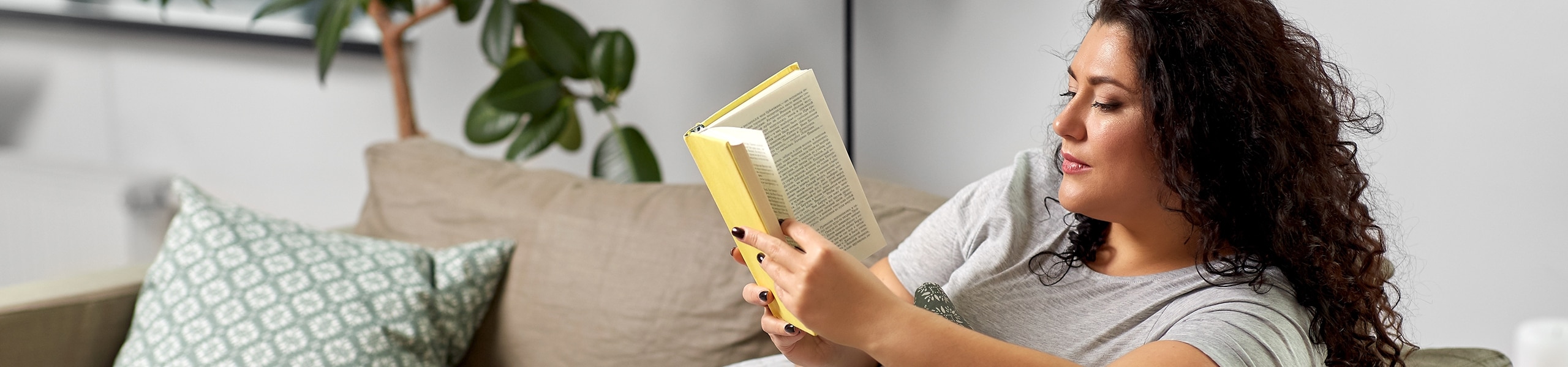 Persona sentada en un sillón leyendo un libro