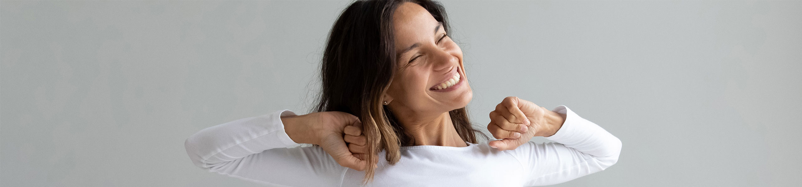 Smiling person stretching in bed