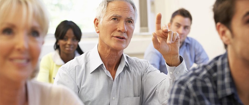 Hombre levantando la mano en una clase