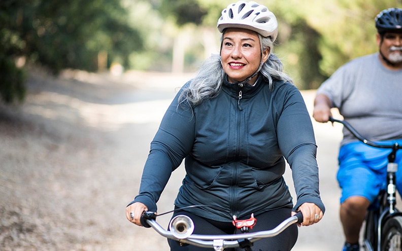 Mujer que anda en bicicleta para hacer ejercicio