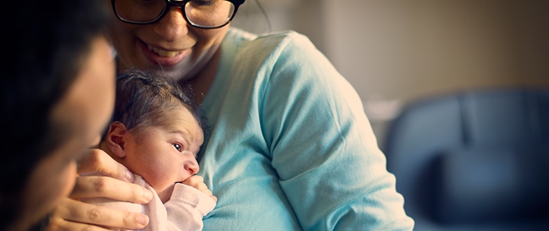 Mamá con su bebé recién nacido en brazos en el hospital.