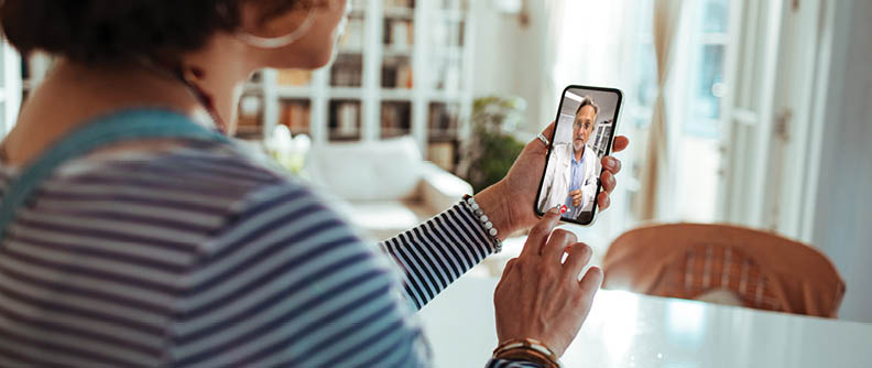 Persona en una videoconsulta prenatal por teléfono con el médico.