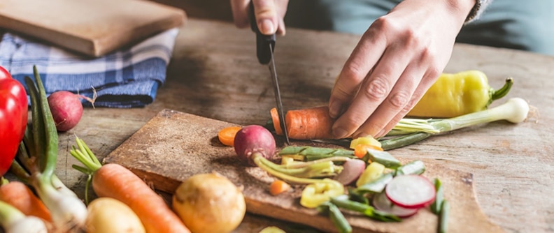 Persona cortando vegetales sobre una tabla