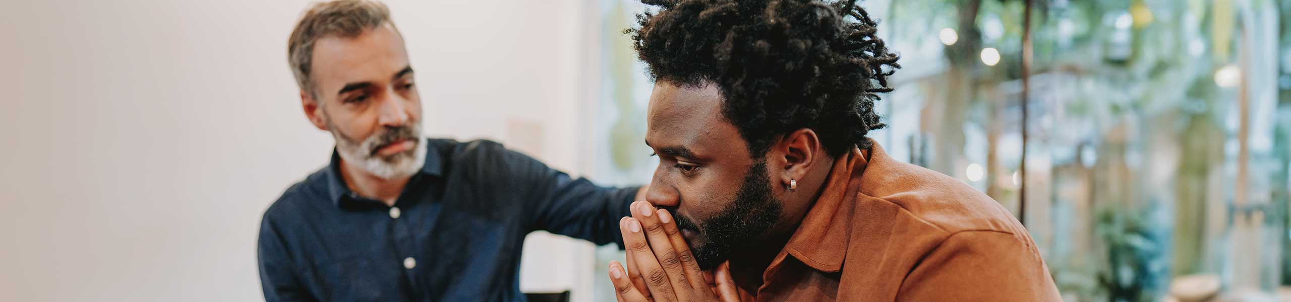Man showing emotional support for a male friend