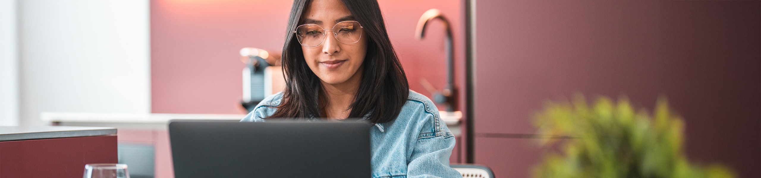 Persona adulta joven sentada trabajando en su computadora portátil