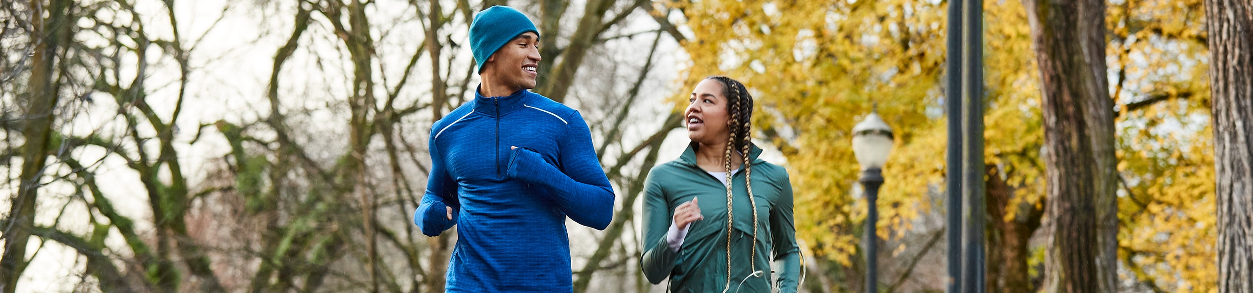 A smiling man and woman jog outside