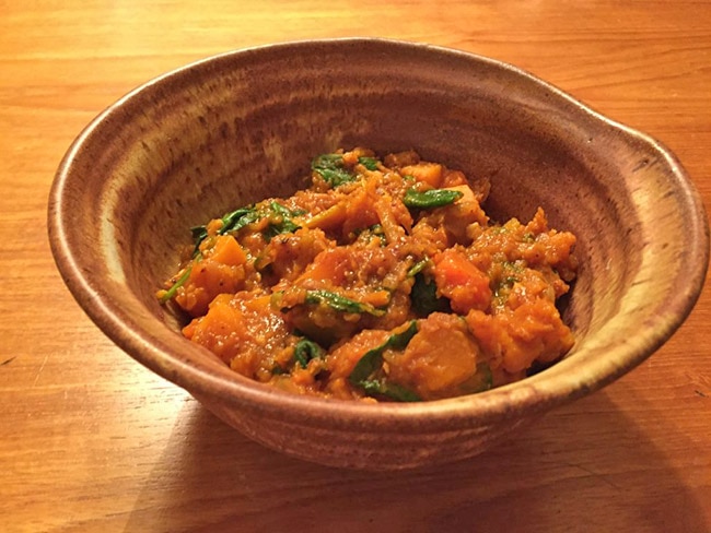 A bowl of curried butternut squash and lentil stew with apple.