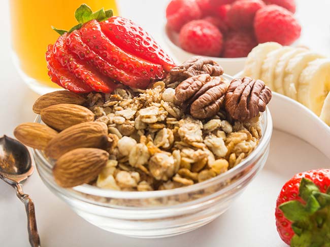 Bowl of granola with strawberries, almonds, and pecans