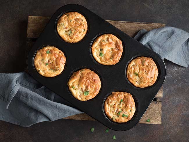 Mini asparagus frittatas in a muffin baking pan.