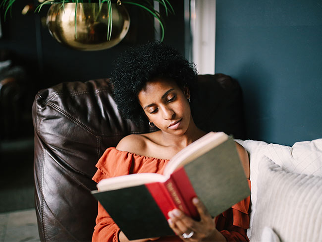 Woman sitting in a comfy chair while reading.