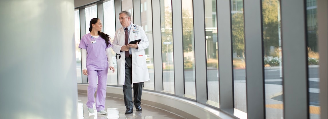 physician and assistant in hallway