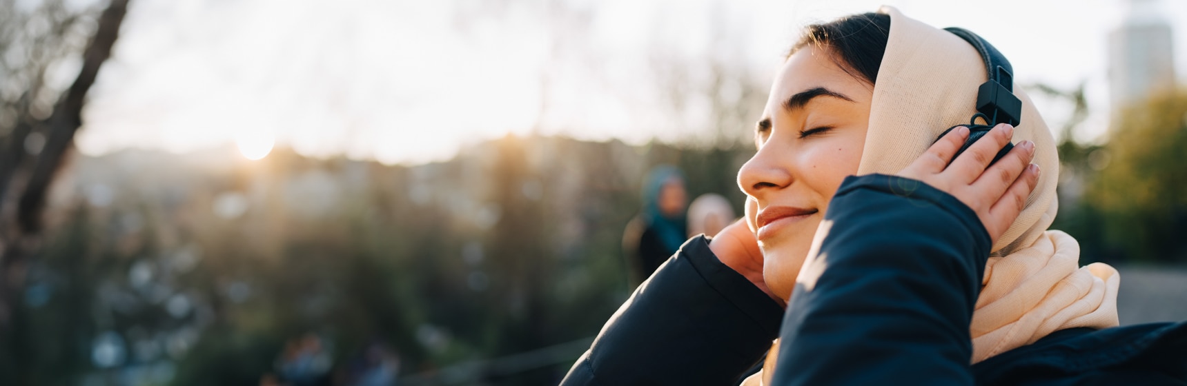 Persona con los ojos cerrados disfrutando de escuchar música en sus auriculares