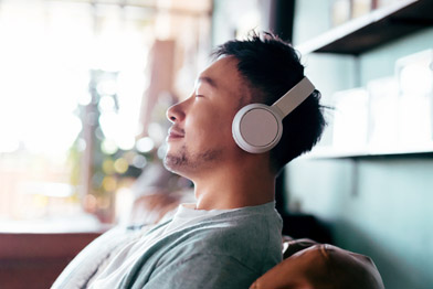 Persona con los ojos cerrados escuchando con auriculares