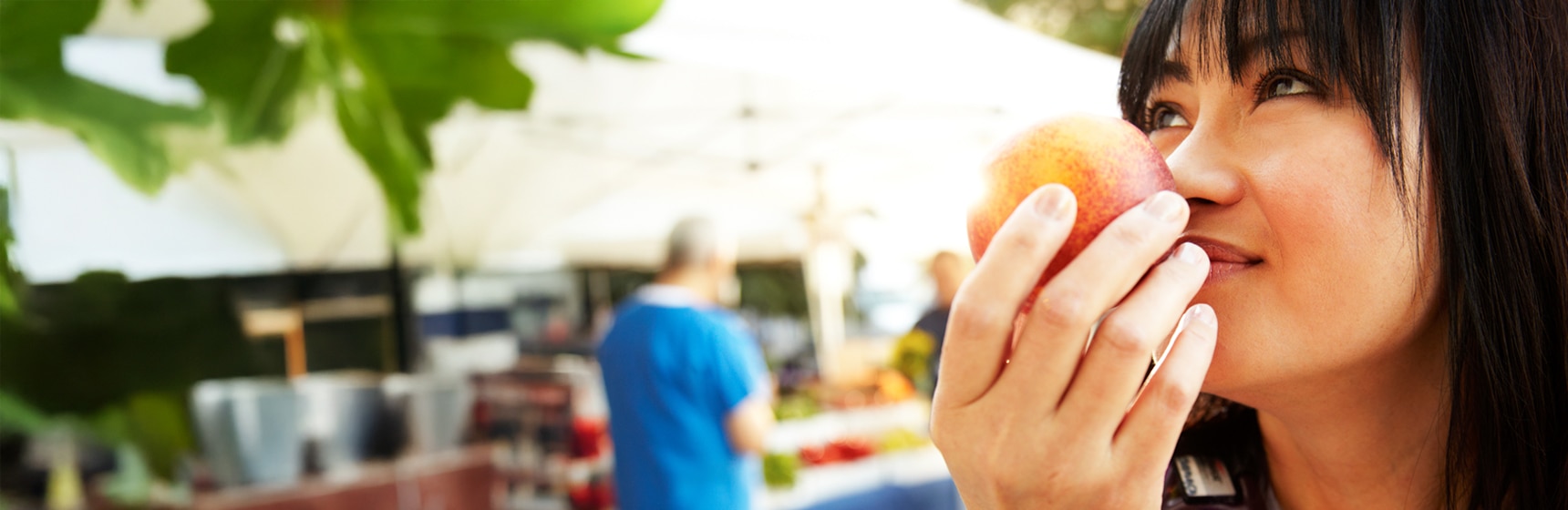 Persona de compras revisando una fruta en el mercado