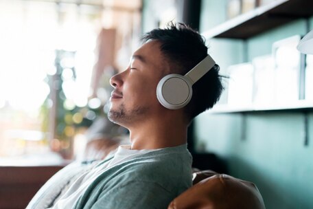 Young person wearing headphones with eyes closed