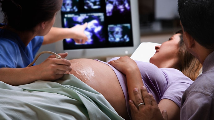 Nurse using an ultrasound on a pregnant mother