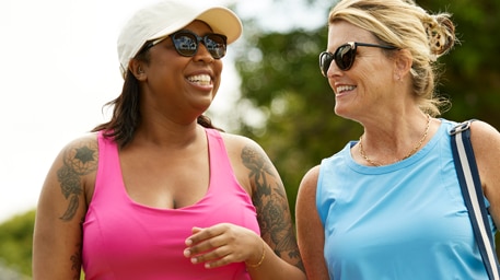 Dos personas caminando en la naturaleza mientras conversan