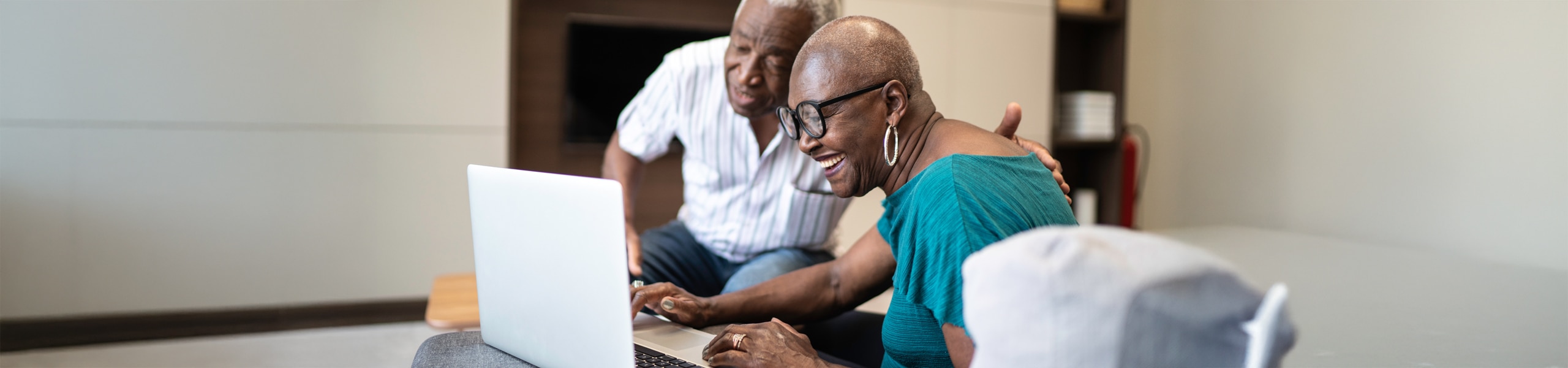 Pareja adulta mirando la pantalla de una computadora portátil