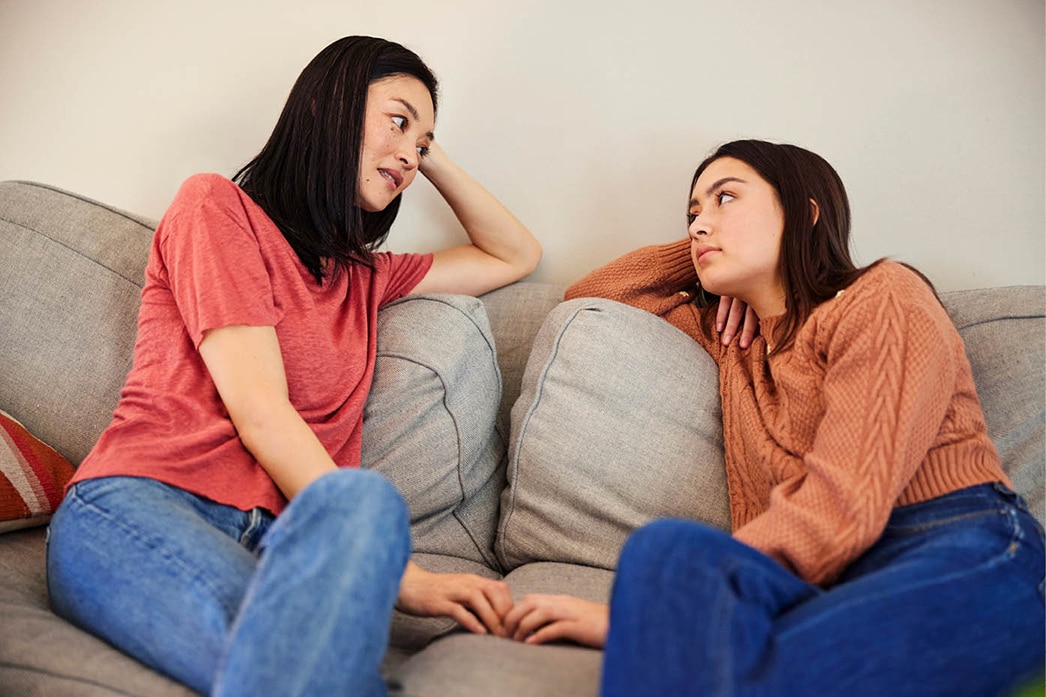 Persona y adolescente hablando en un sofá