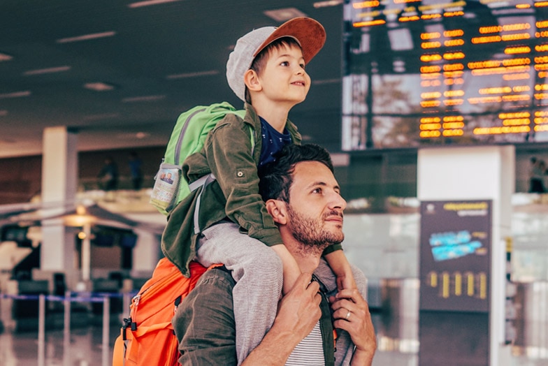 Padre yéndose de viaje con su hijo a cuestas