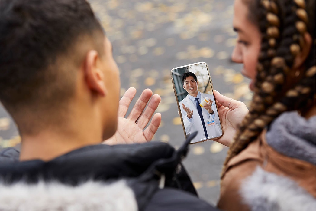 Personas hablando con un médico a través de un dispositivo móvil