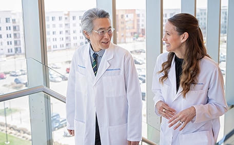 Dos médicos de Kaiser Permanente caminando y conversando en un consultorio médico