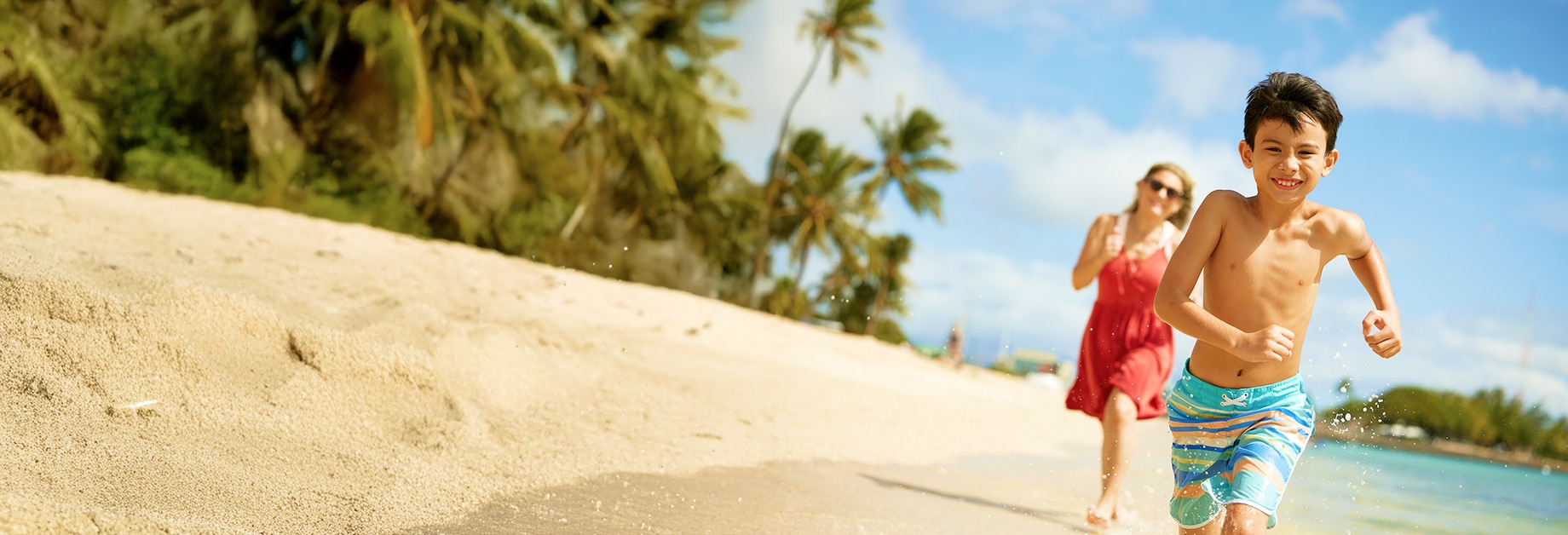 Hijo y madre corriendo en la playa
