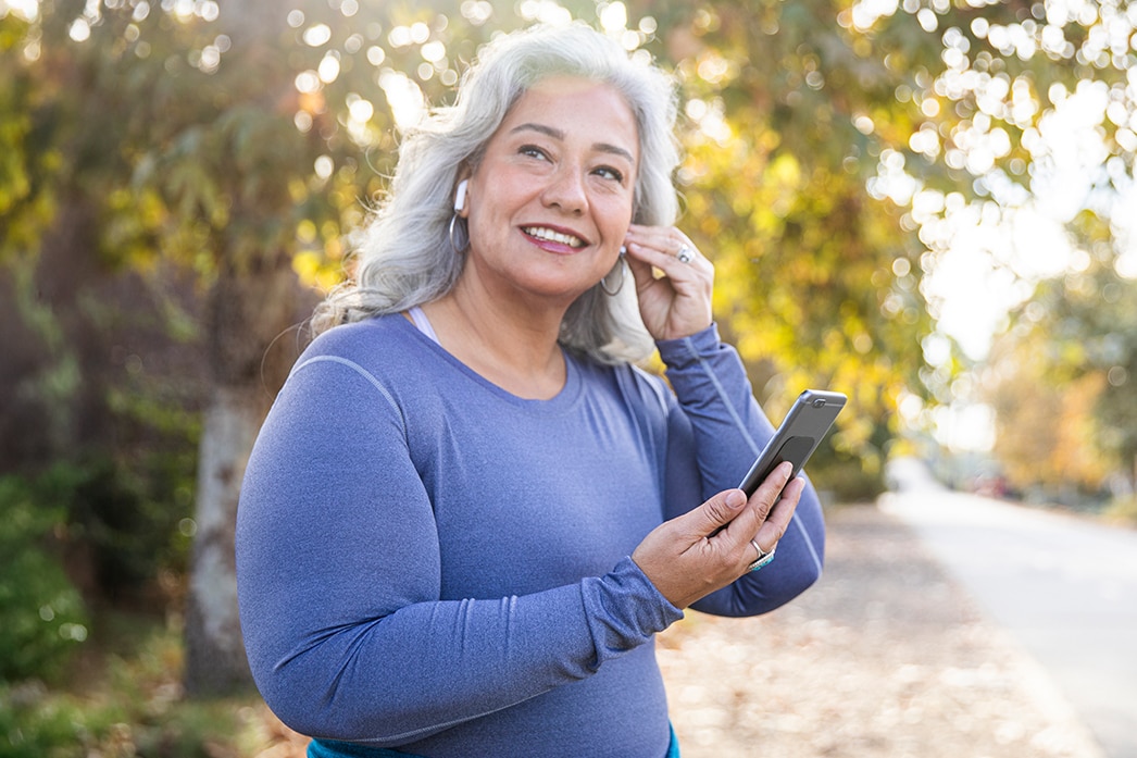 Una persona sonriendo mientras se pone los auriculares