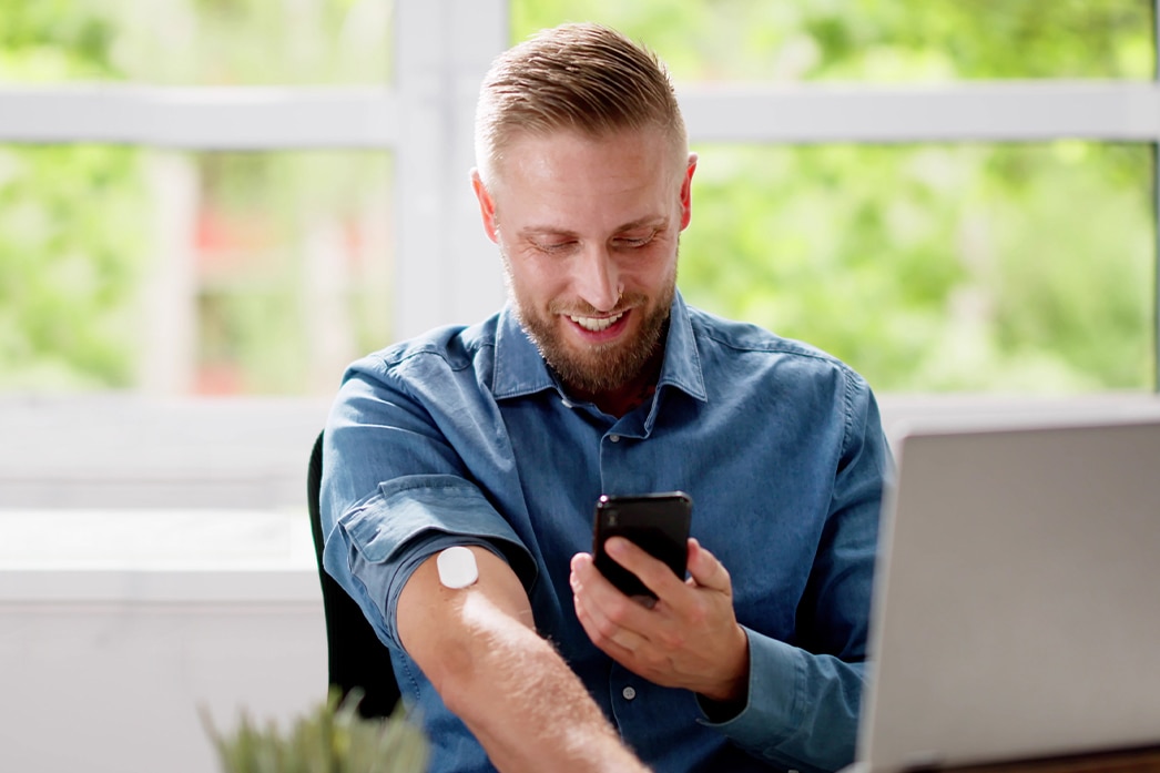 Una persona usando el teléfono para monitorear su diabetes