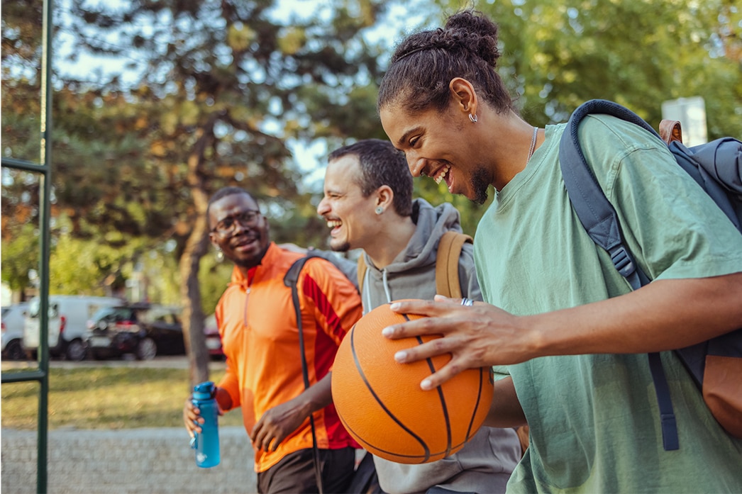 Amigos caminando hacia el parque para jugar baloncesto