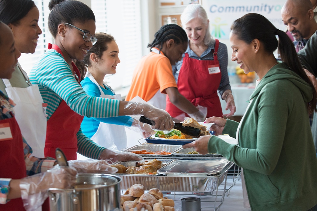 Personas ayudando de manera voluntaria y entregando comida