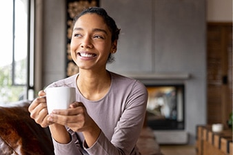 Persona sosteniendo una taza y sonriendo