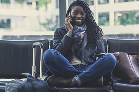 Persona sentada en un aeropuerto hablando por teléfono