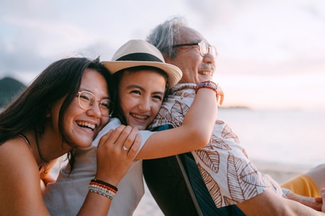 Familia abrazada en una playa