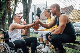 Personas sentadas y hablando en una cancha de baloncesto