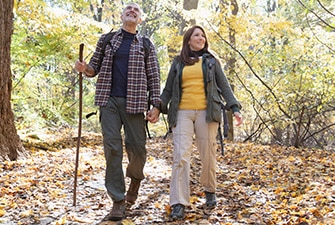 Una pareja caminando de la mano por el bosque