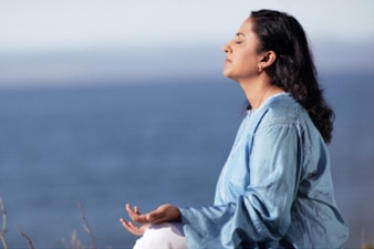 Persona sentada meditando al aire libre