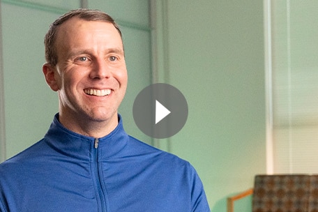 Video play button over image of Kaiser Permanente Colorado member talking