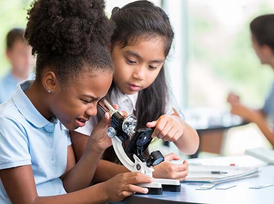 Two children looking through a microscope
