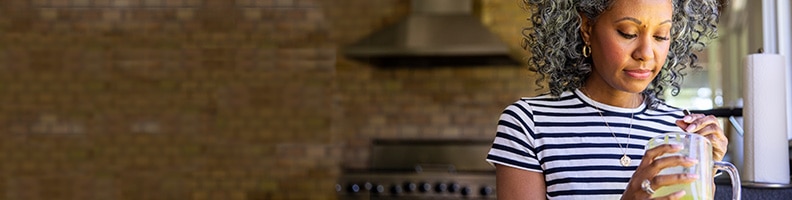 woman making smoothie in kitchen