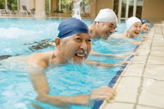 Cuatro personas haciendo ejercicio una al lado de la otra en una piscina