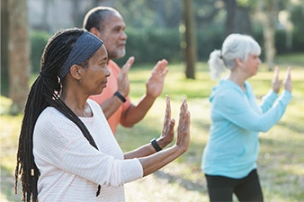 Grupo de personas adultas practicando taichí en el parque