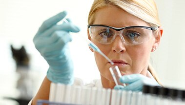 Woman adding liquid to a test tube