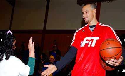 Fotografía de Stephen Curry chocando las manos con una niña