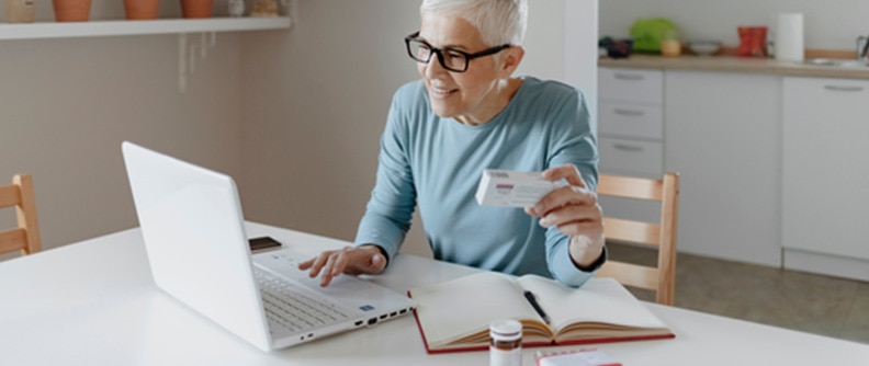 woman reading medication info from laptop